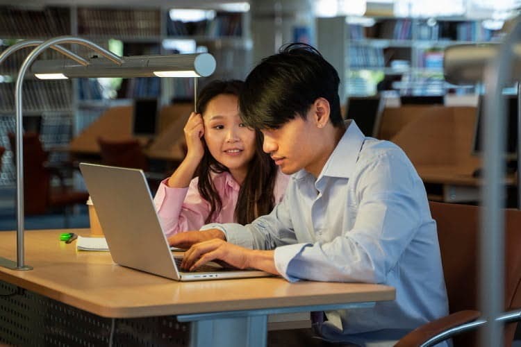 hai người bạn đang học qua máy tính
